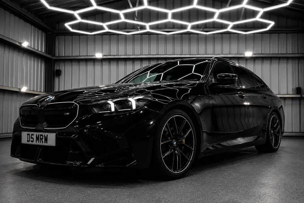 Black BMW in the Day One Detailing studio under hexagonal lights