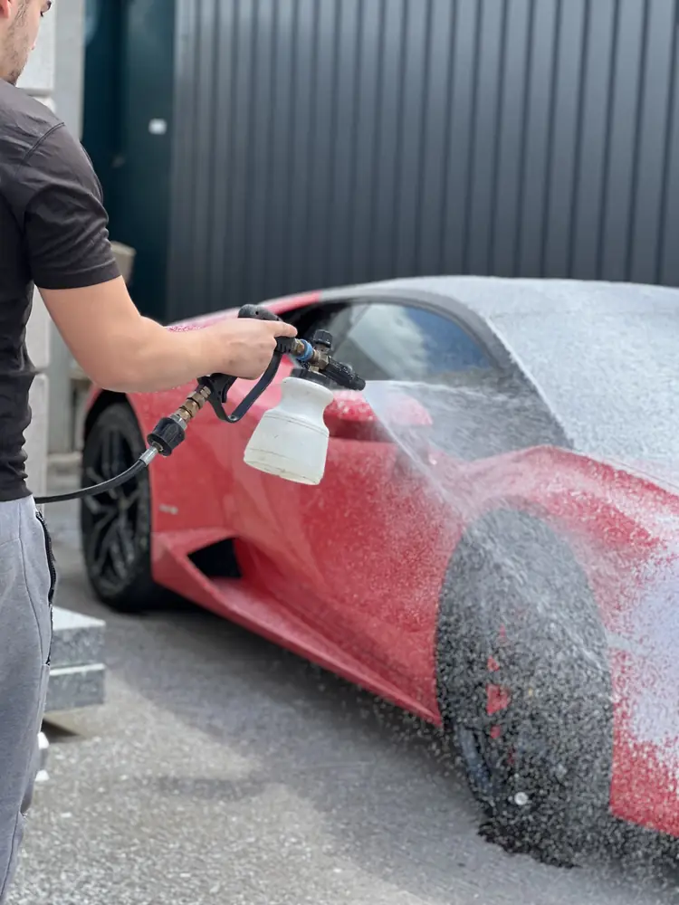Red Lamborghini Hurac&aacute;n covered in snow foam during a safe mobile pre-wash
