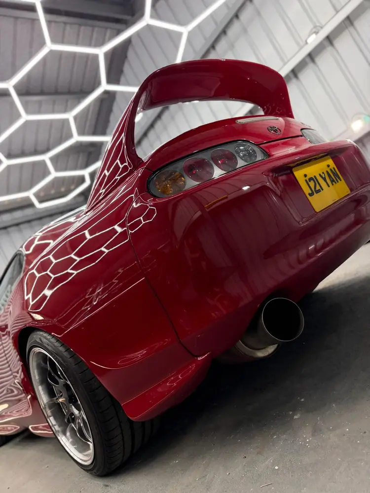 Red Toyota Supra with hexagonal studio light reflections