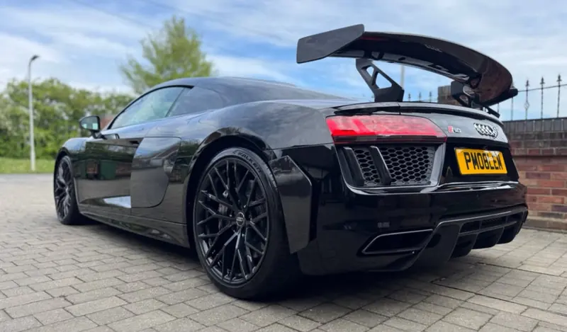 Black Audi R8 with a rear wing, rear three-quarter view after detailing